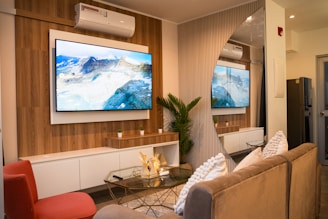 A modern living room with two television screens.
