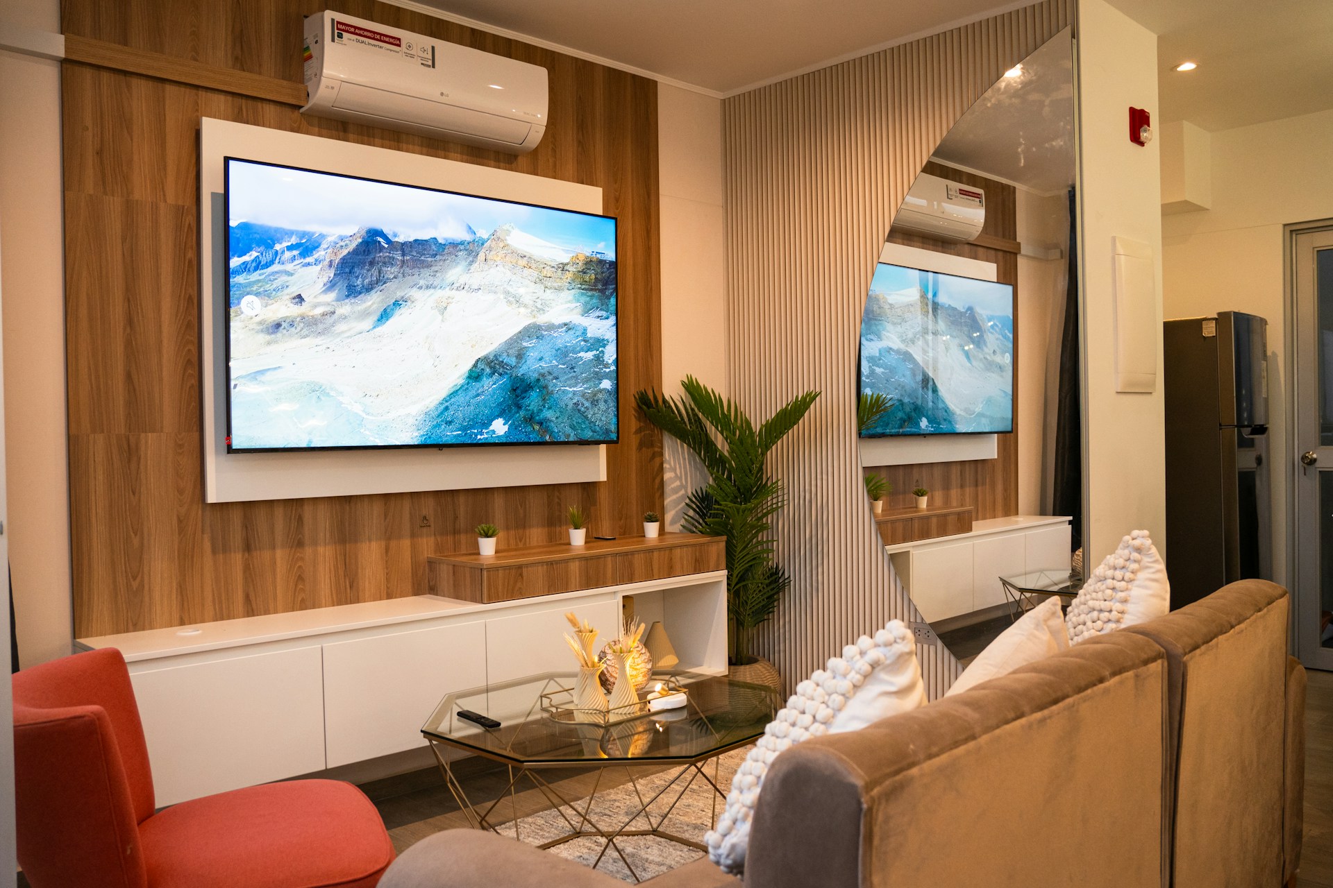 A modern living room with two television screens.