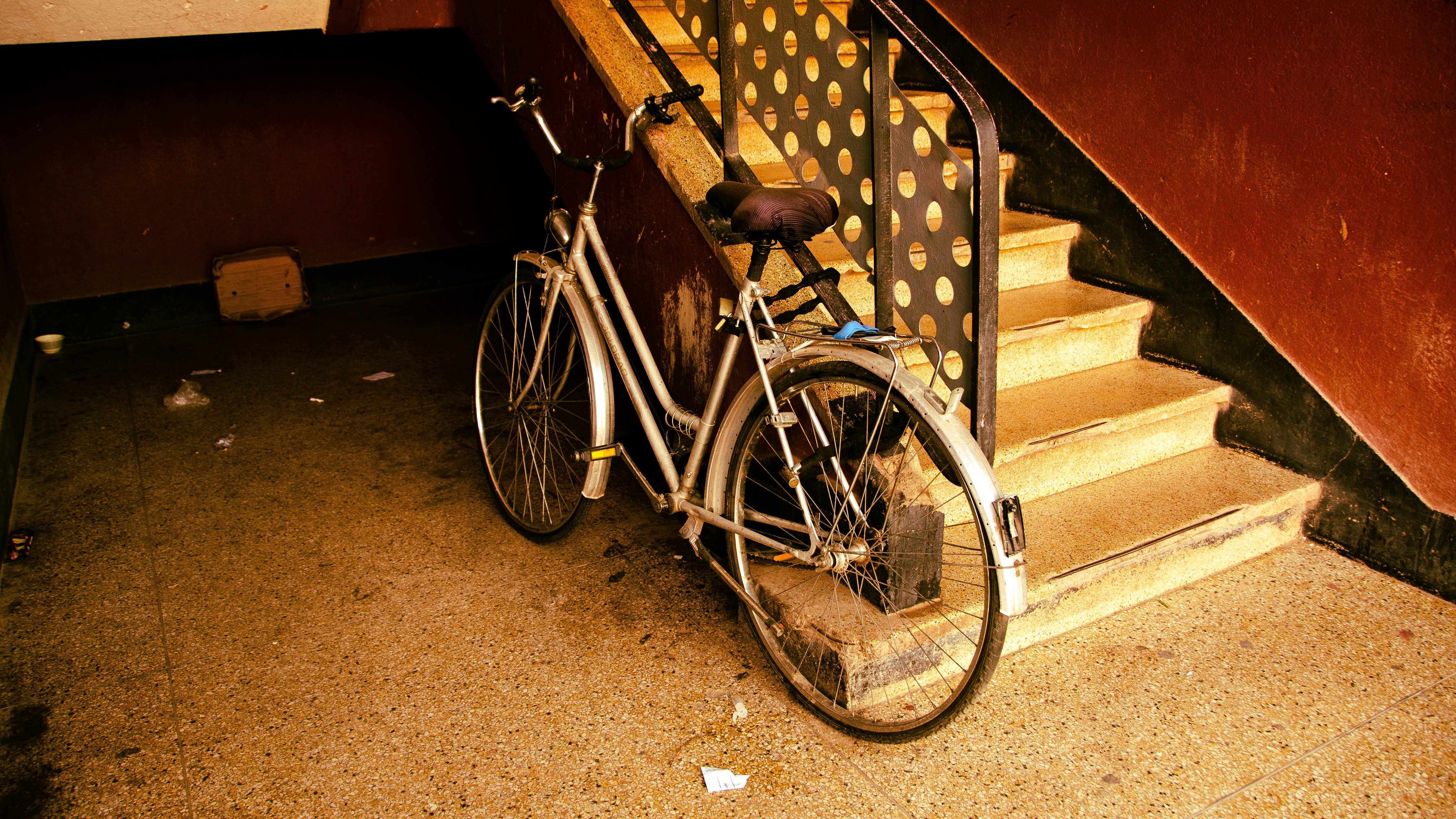 A bicycle is parked beside staircase.
