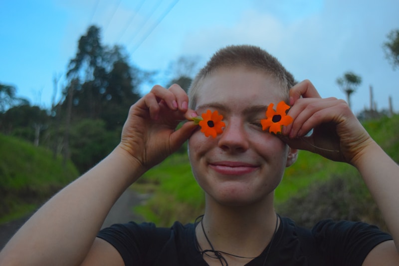 Playful woman with flowers over eyes