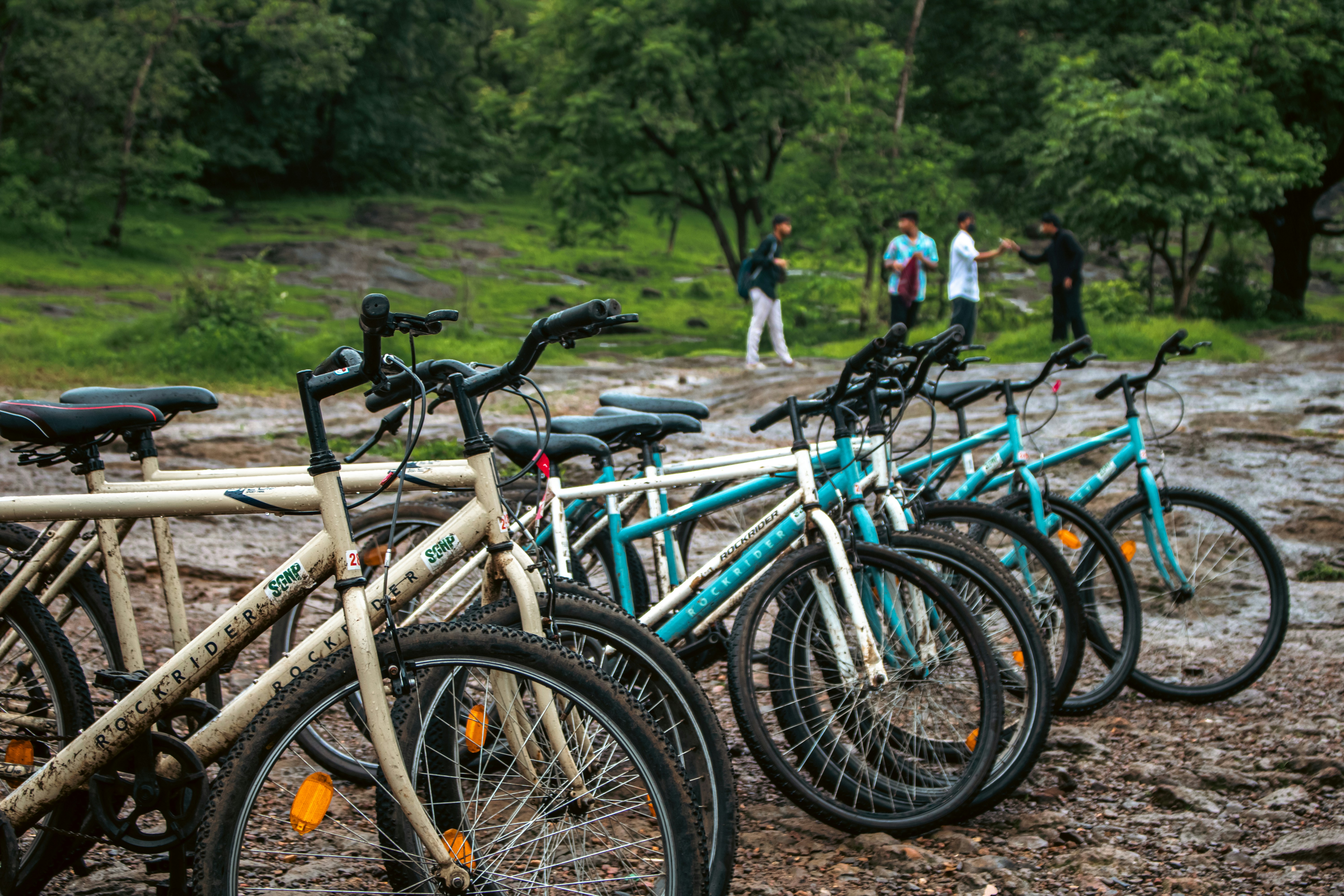 Bikes are parked as people stand in the distance.