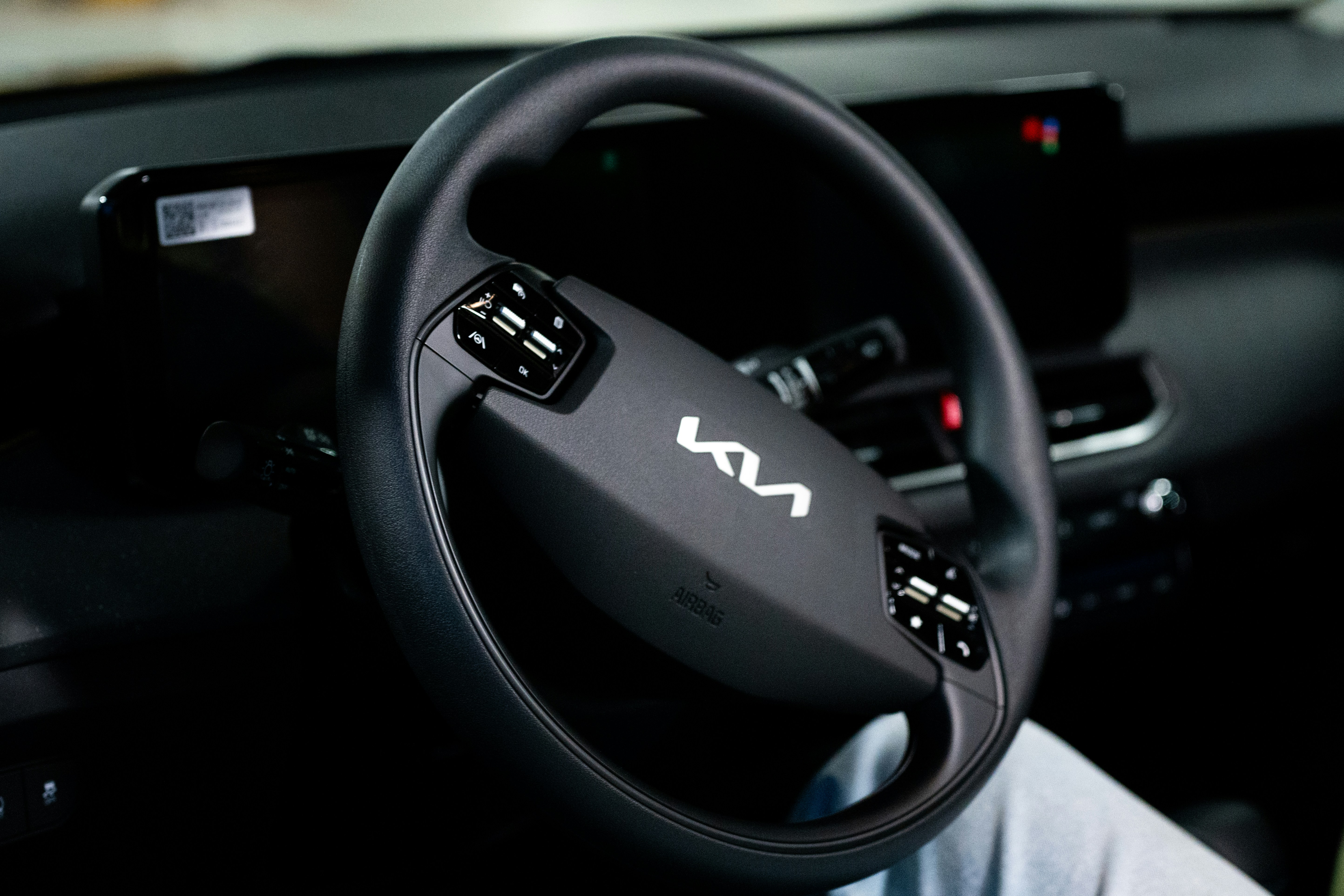 Here is a possible caption: a kia car's steering wheel is visible.