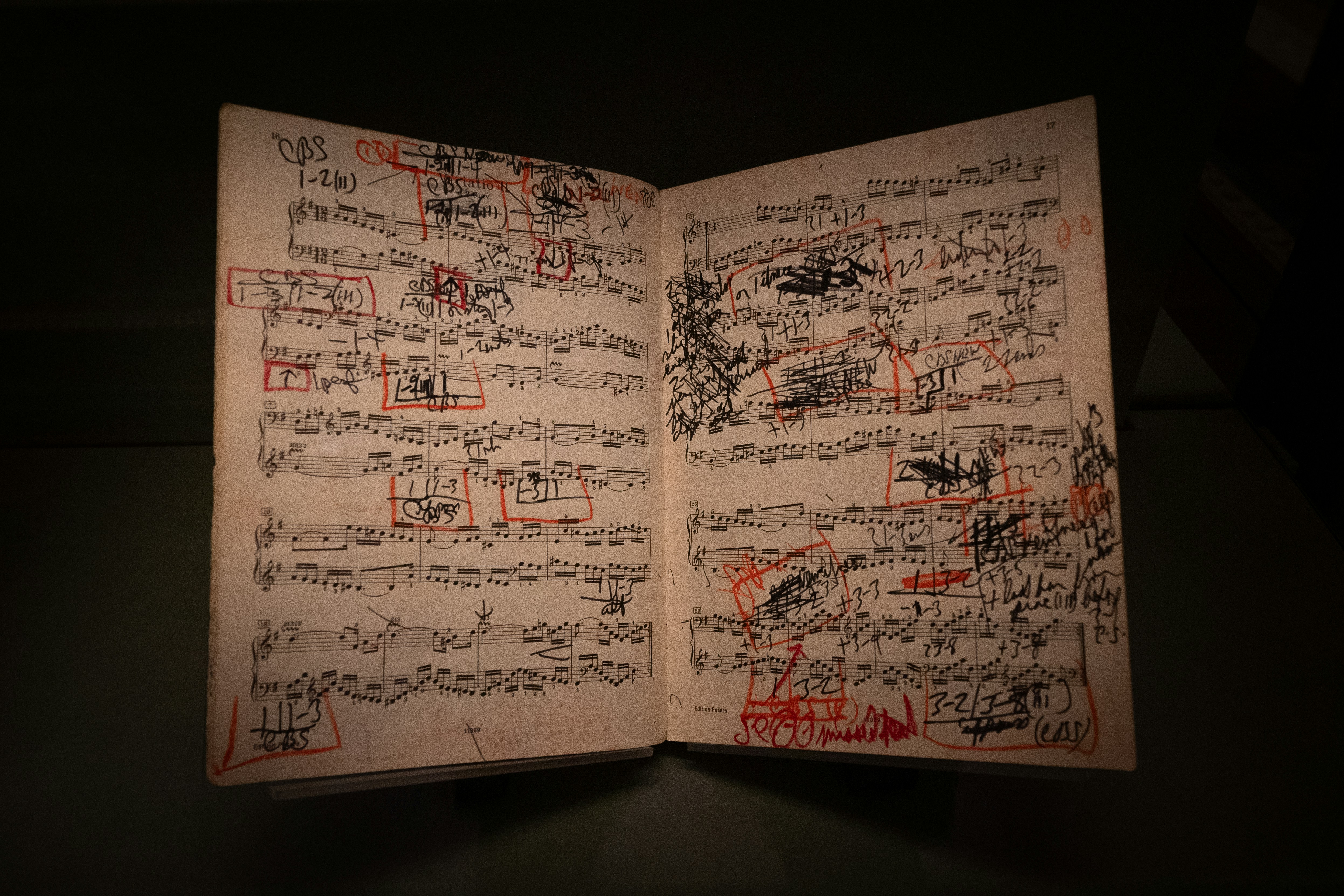 Music sheets are covered with writing and red marks.