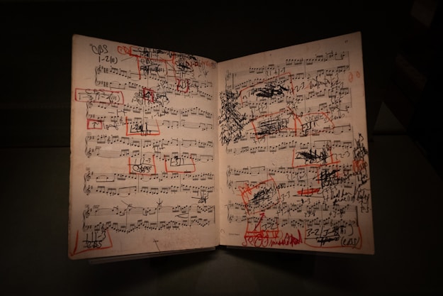 Music sheets are covered with writing and red marks.
