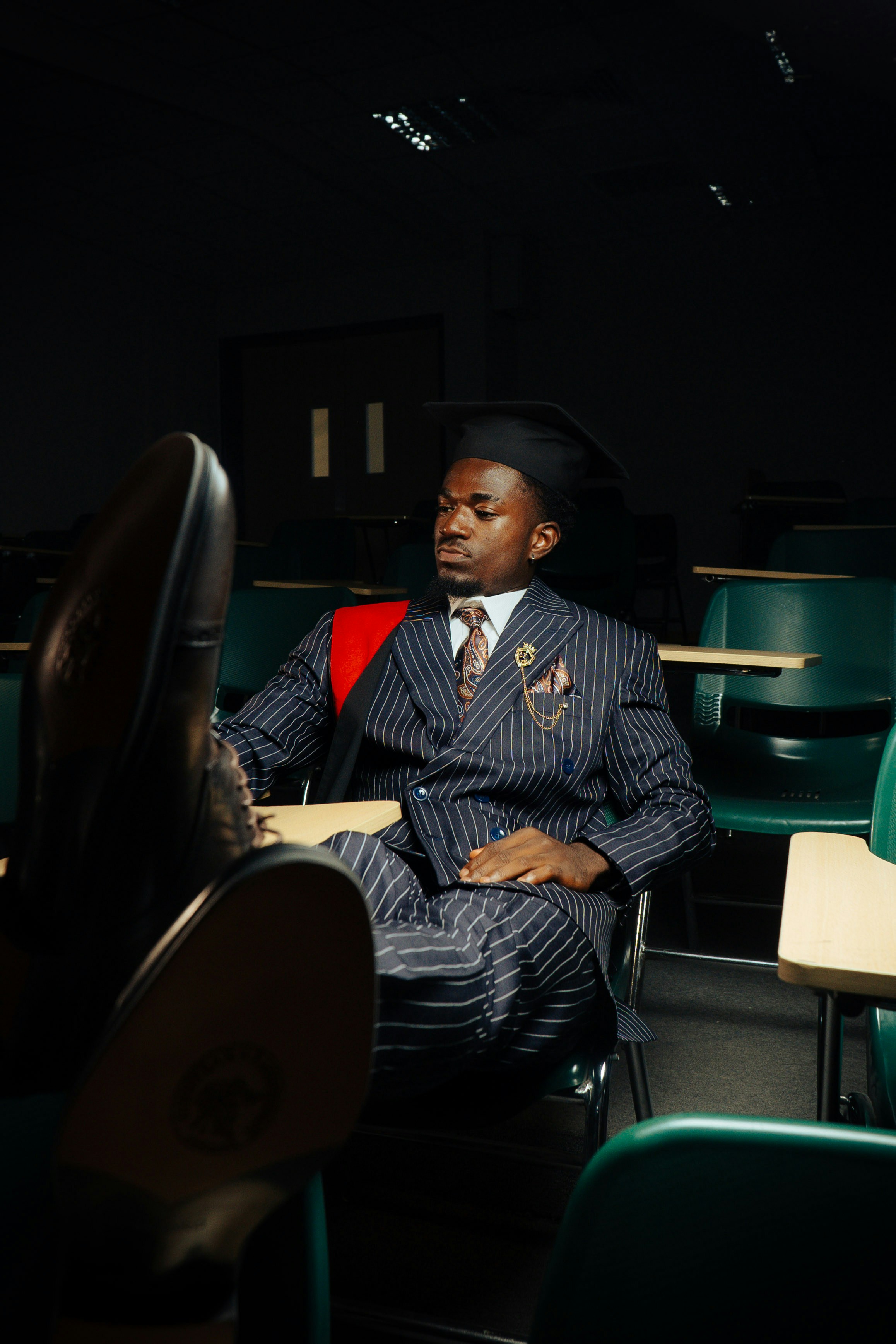 Um homem, de terno, relaxando na sala de aula.