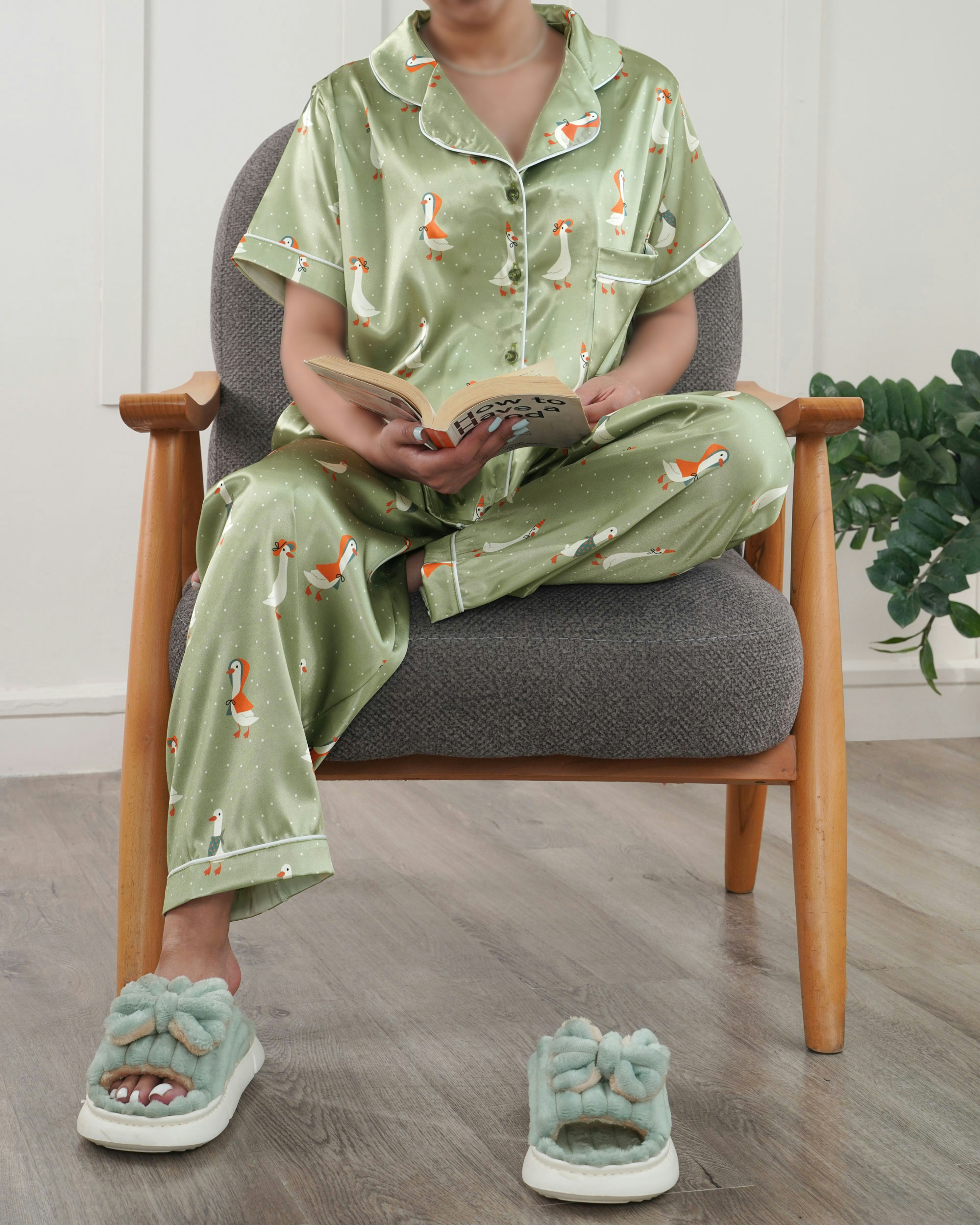 A person reads in pajamas and slippers.