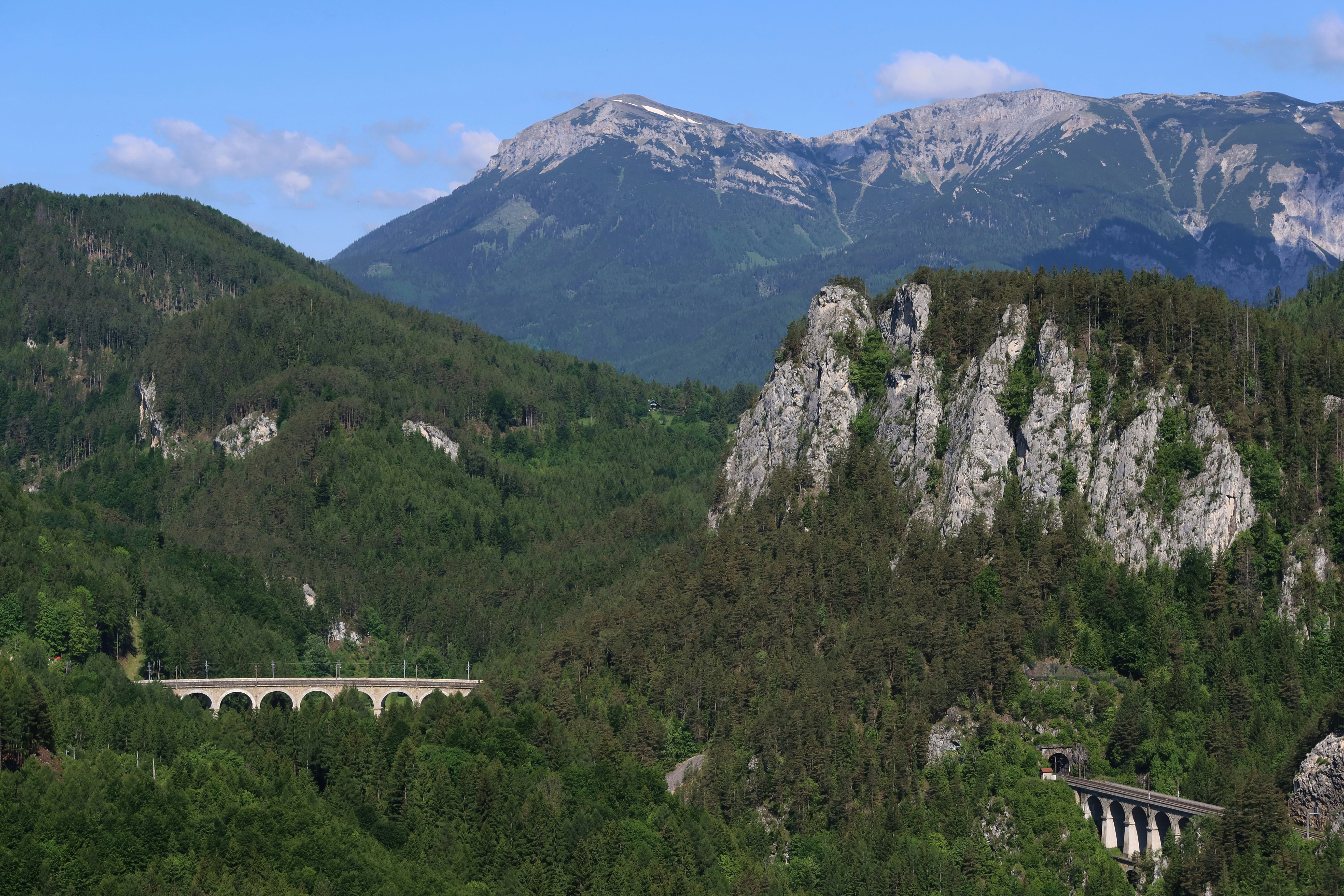 Mountains and valleys are visible with a historic bridge.