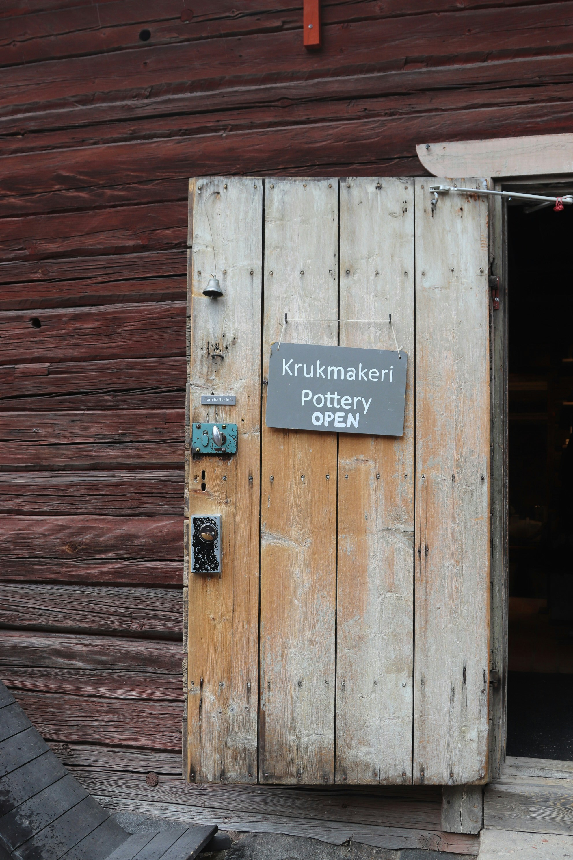 A pottery shop is open, with a rustic door.