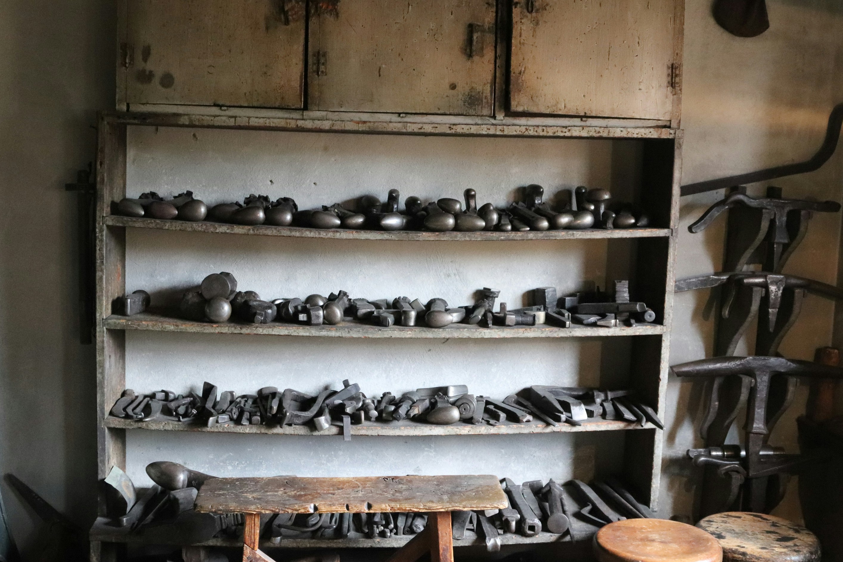 Tools are organized on shelves in a workshop.