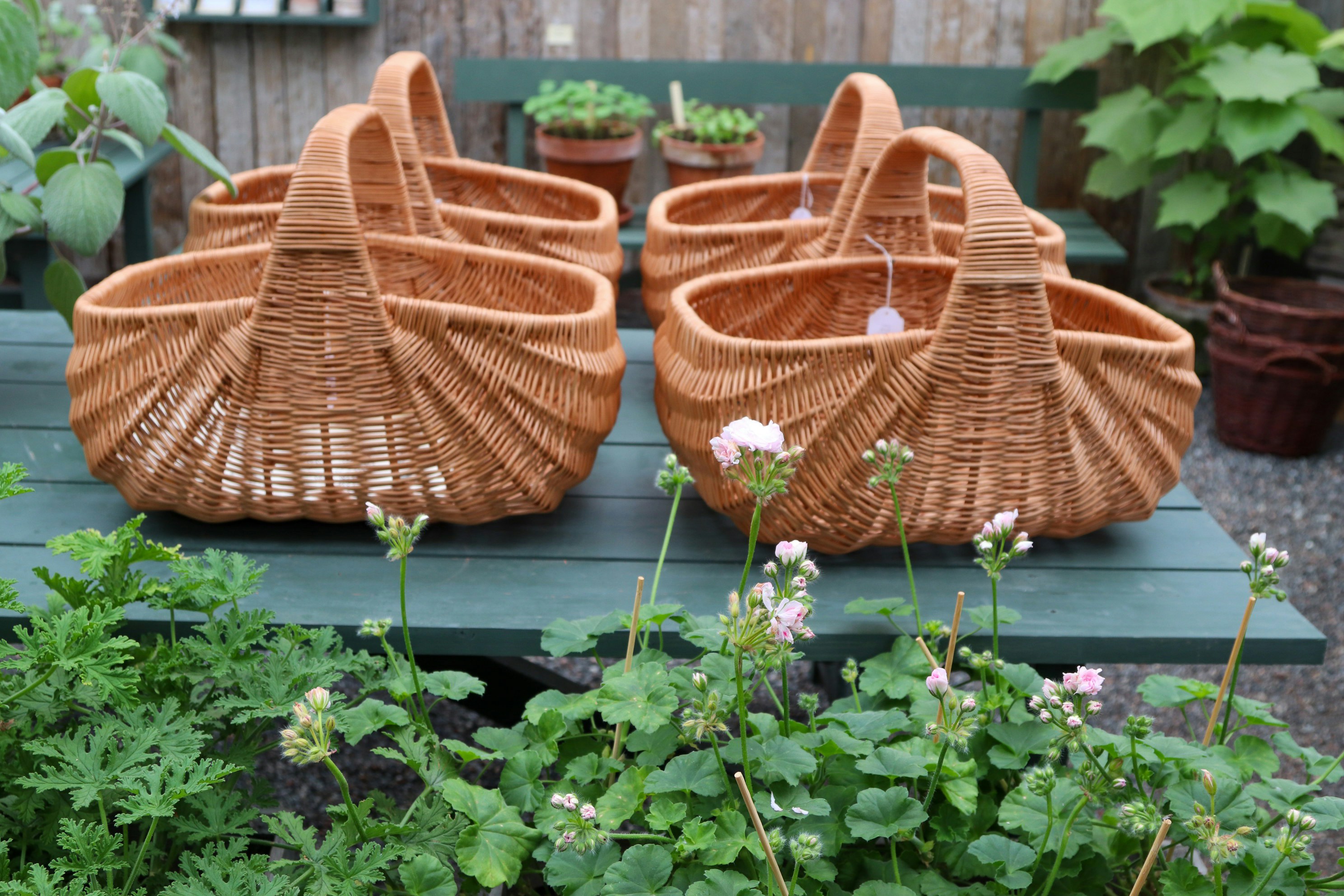 Wicker baskets beside potted plants on a wooden table