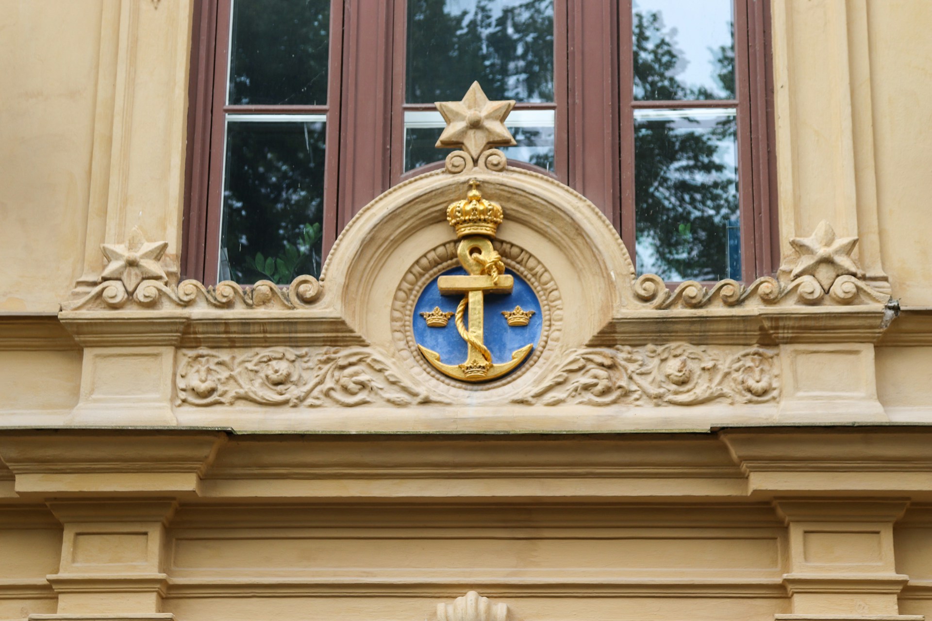A decorative building detail with anchor and crown.