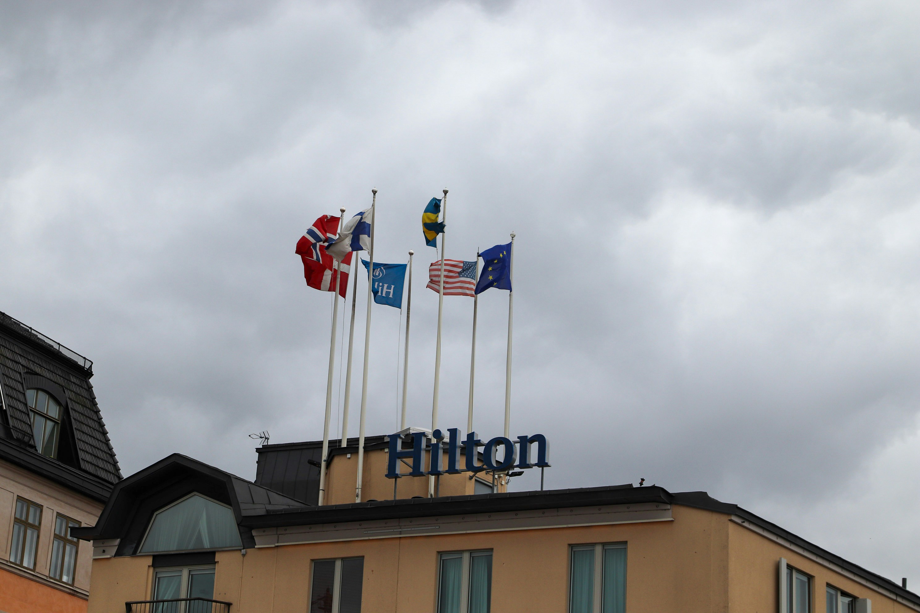 Hilton hotel with flags waving on a cloudy day.