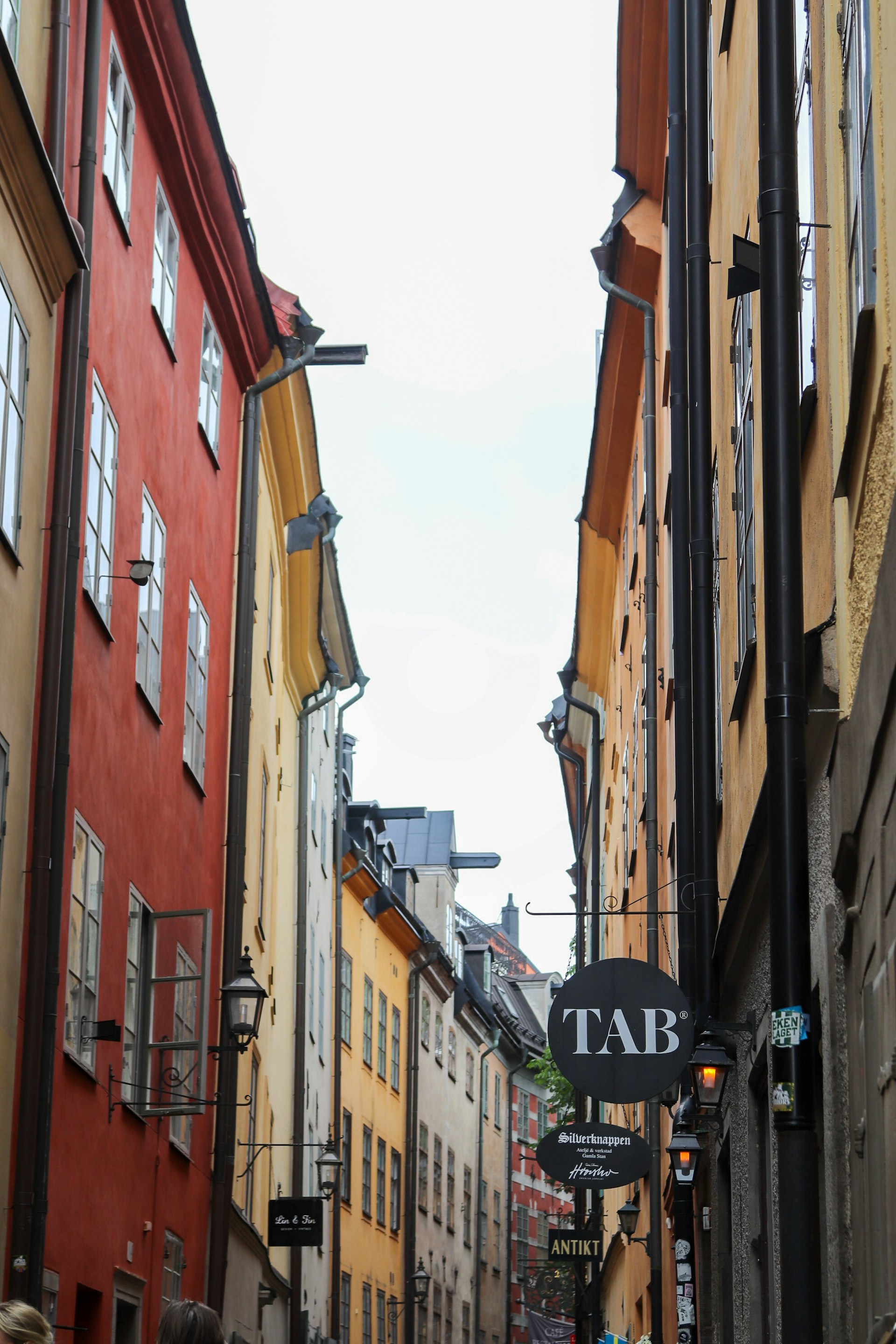 Colorful buildings line a narrow city street.