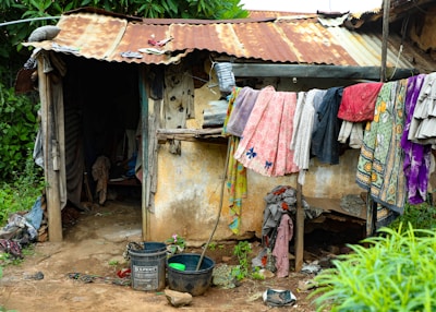 Laundry hangs outside a weathered, rustic dwelling.