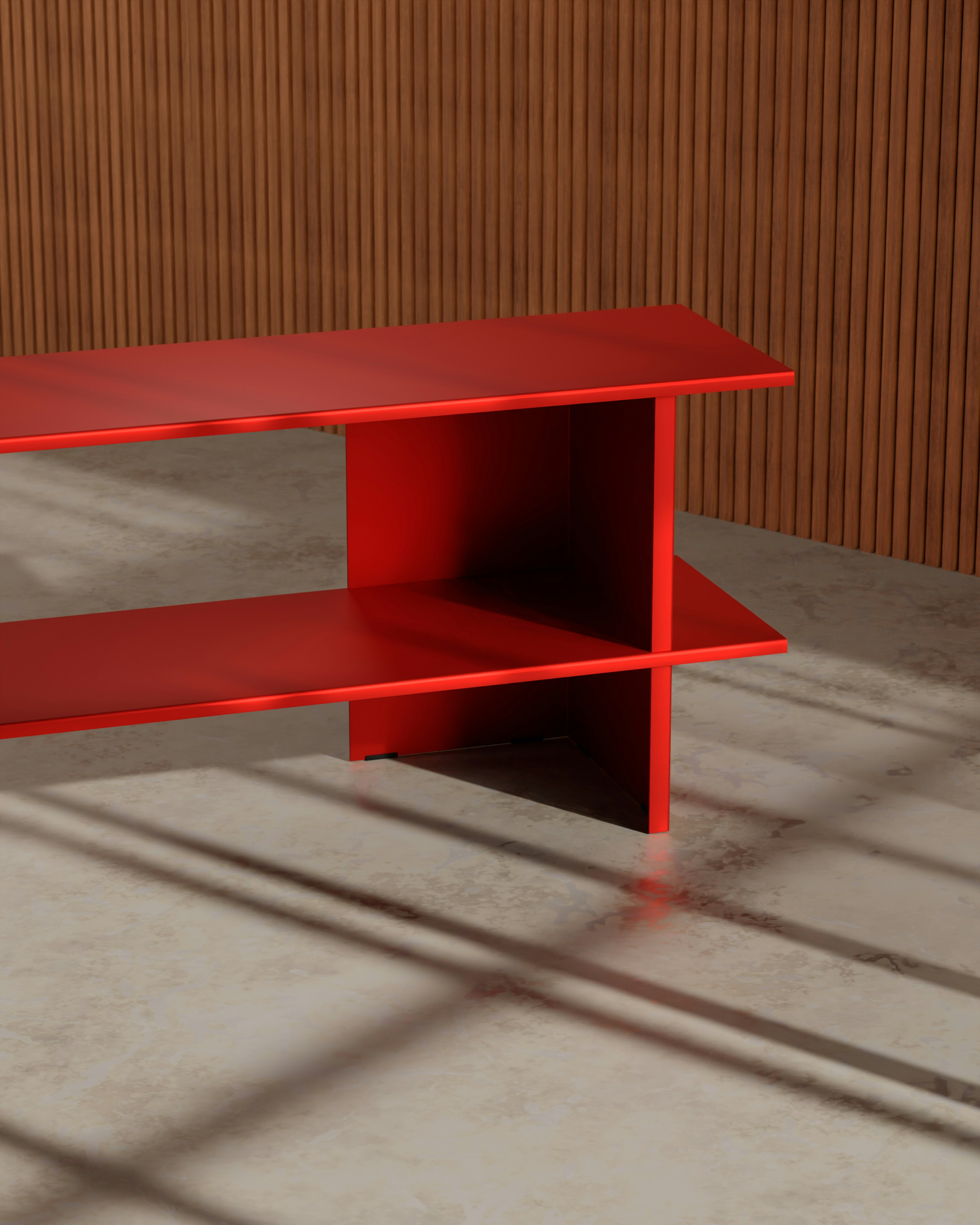 Ein roter Tisch steht vor einer braunen Wand.