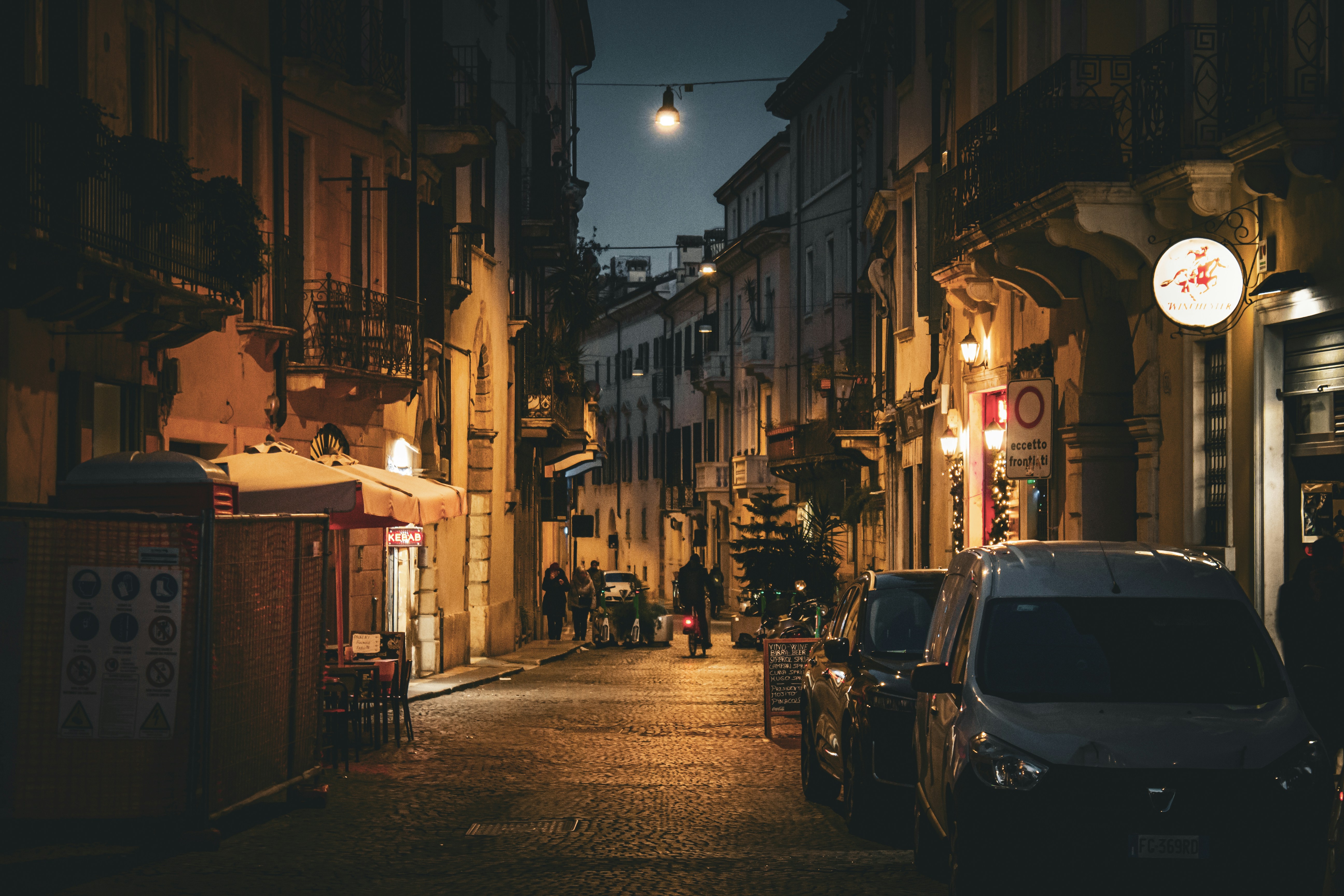 A dark, cobblestone street at night.