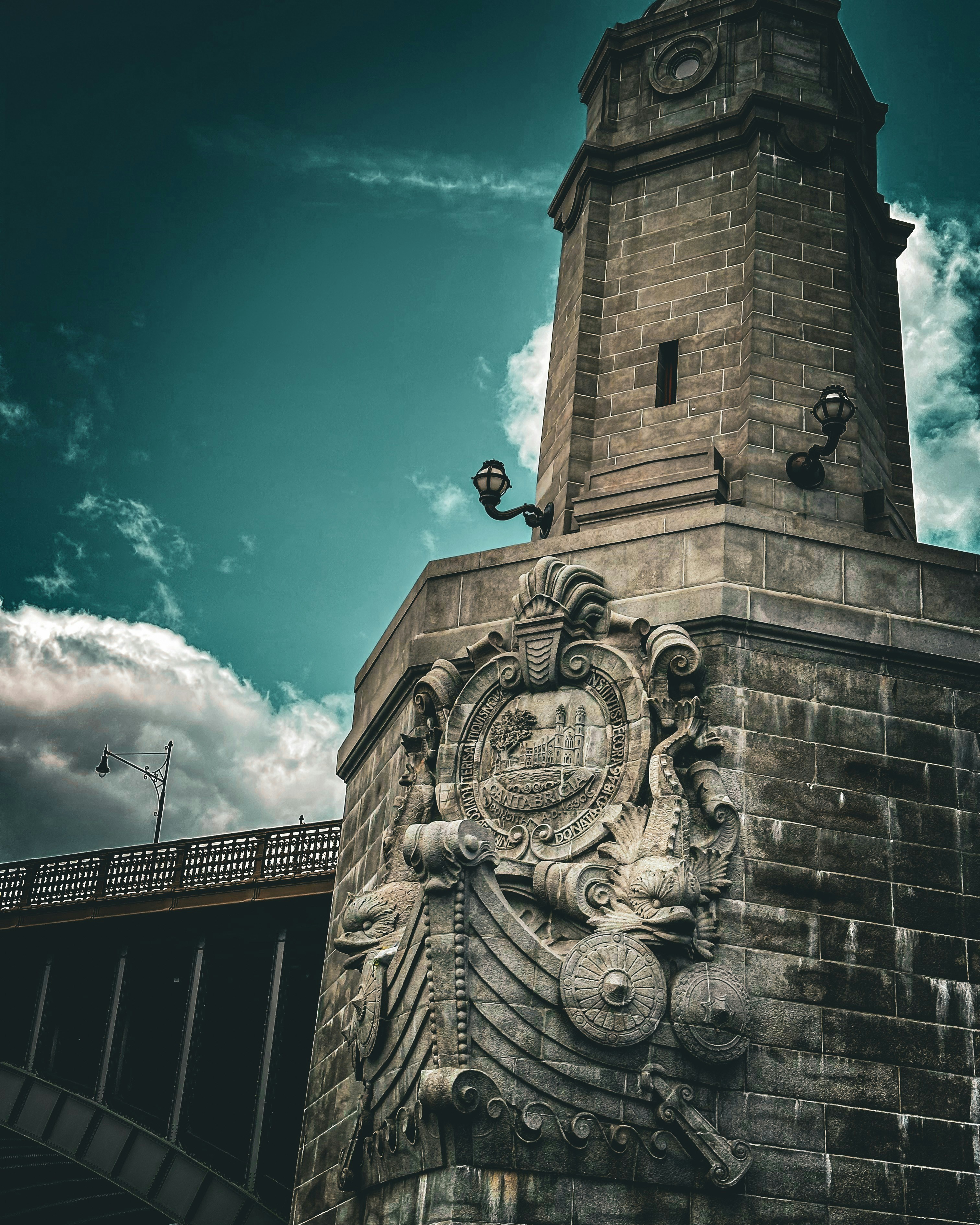 A detailed stone tower stands against a dramatic sky.
