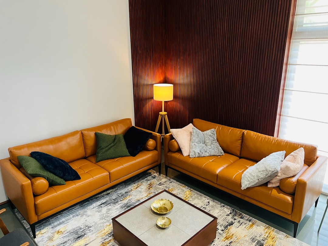 Two leather couches comfortably furnish a warm room.