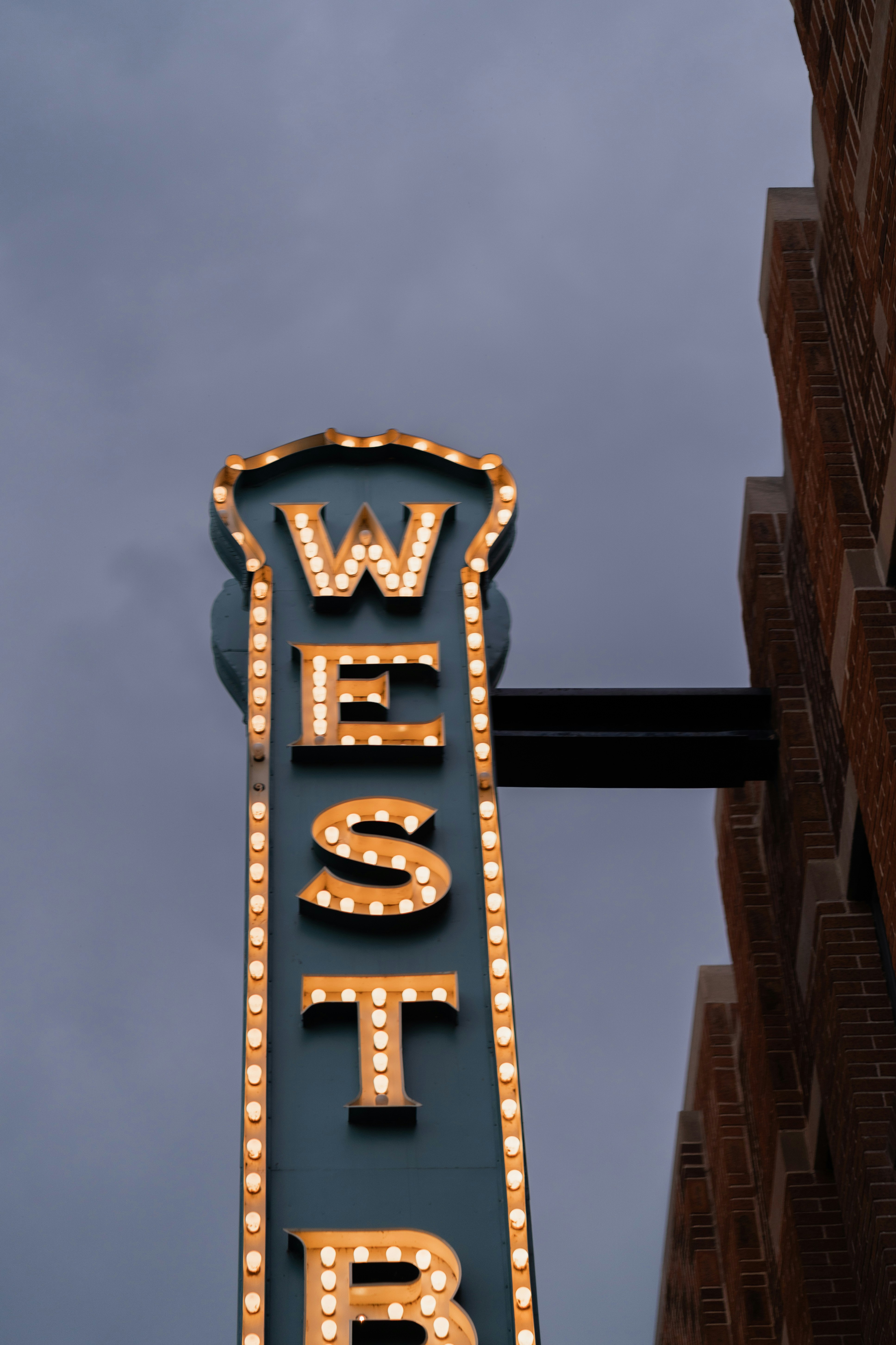 A lit-up sign reads "west" in an outdoor shot.