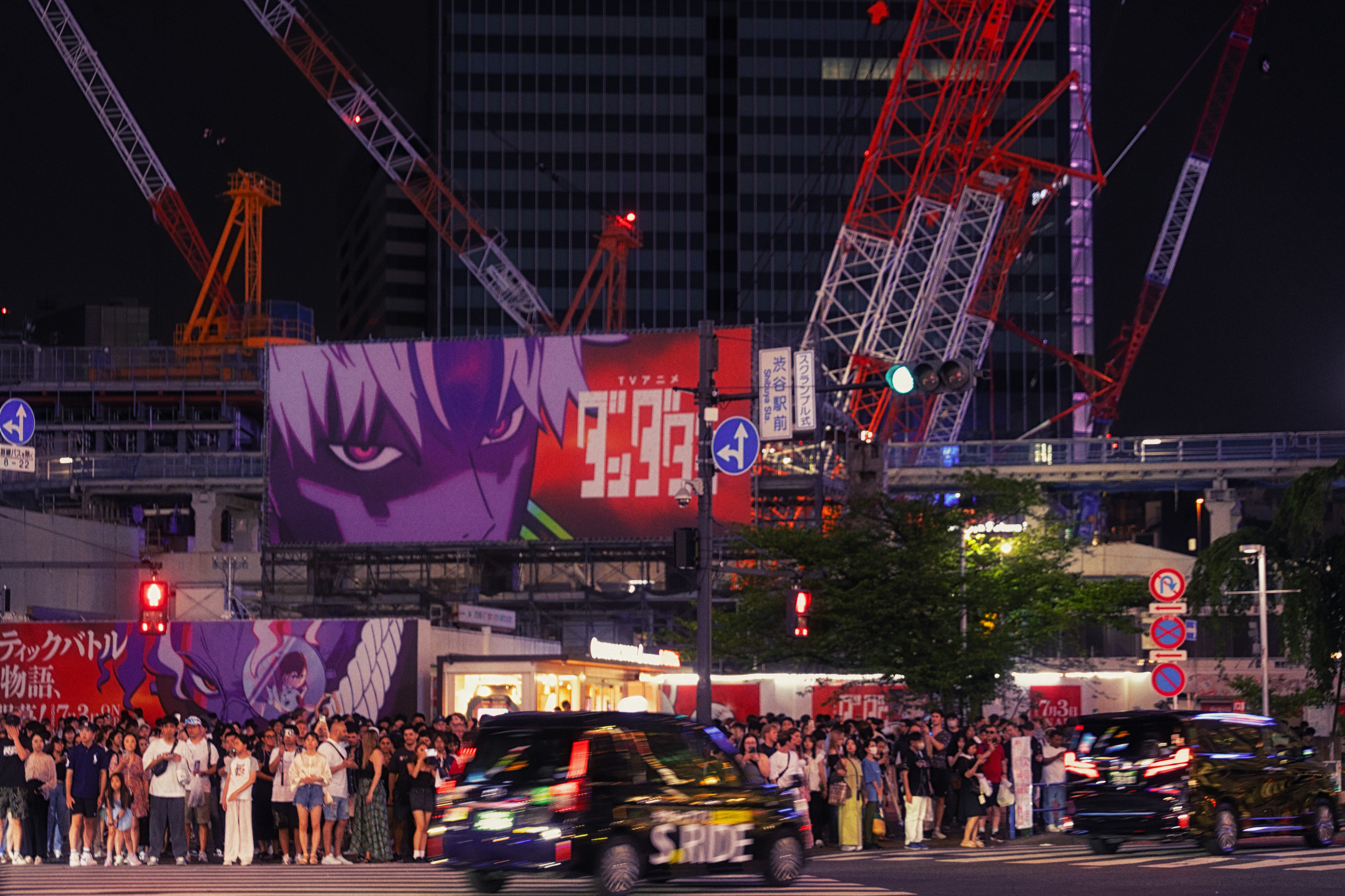 Nighttime cityscape with a large animated advertisement.
