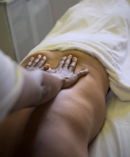 A masseuse is giving a back massage.