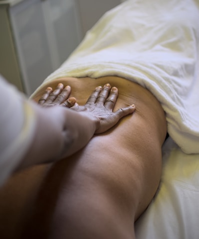 A masseuse is giving a back massage.