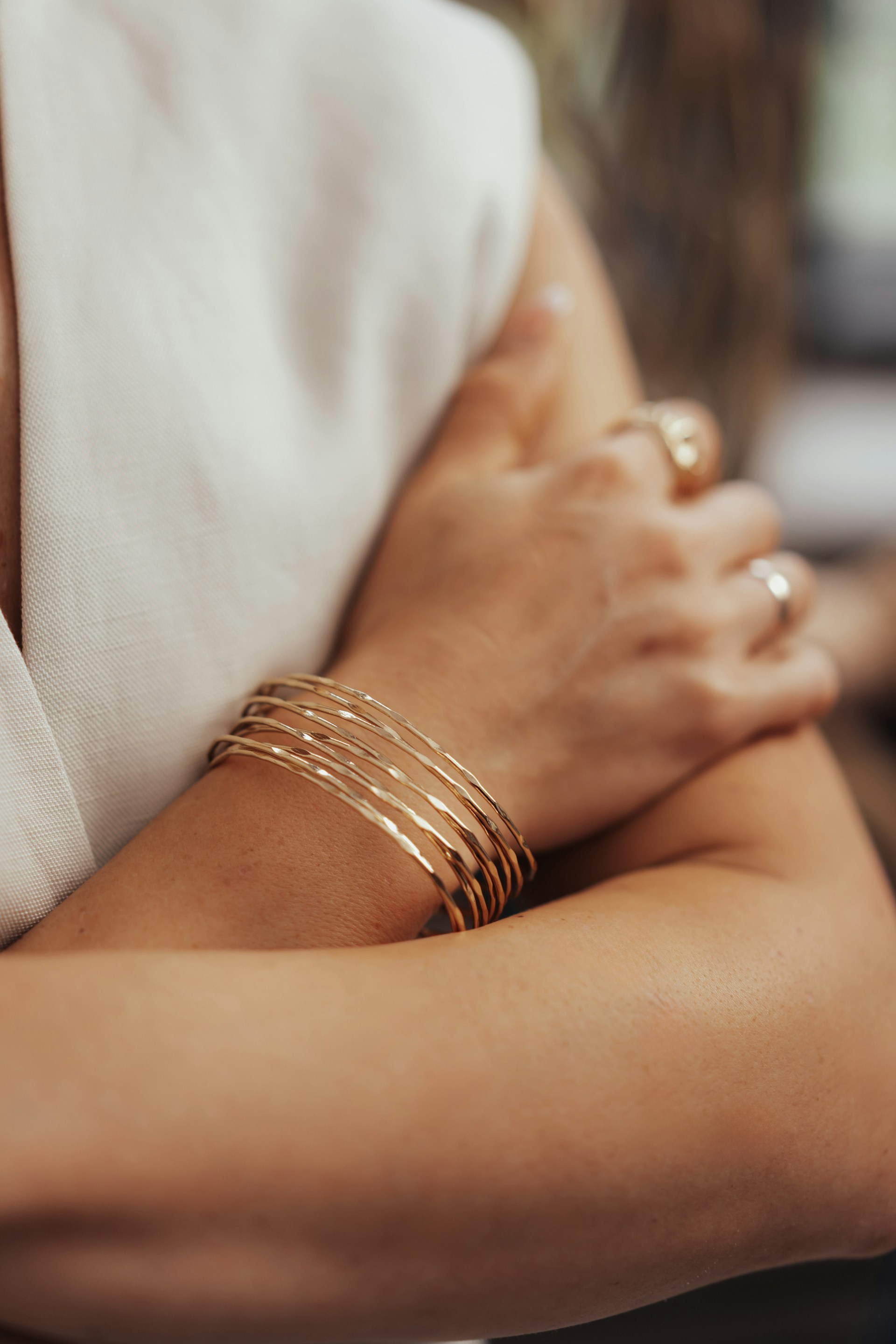 A woman's arms adorned with gold jewelry.