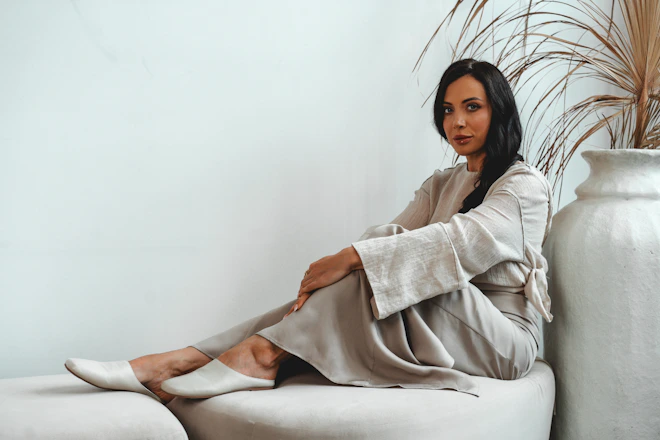 Woman poses gracefully while sitting on a sofa