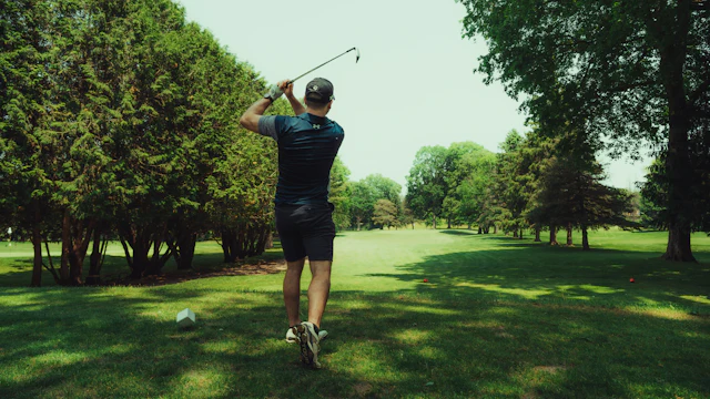 Golfer taking a swing on a sunny fairway