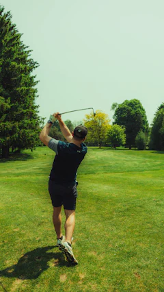 Golfer swinging a club on a lush green course