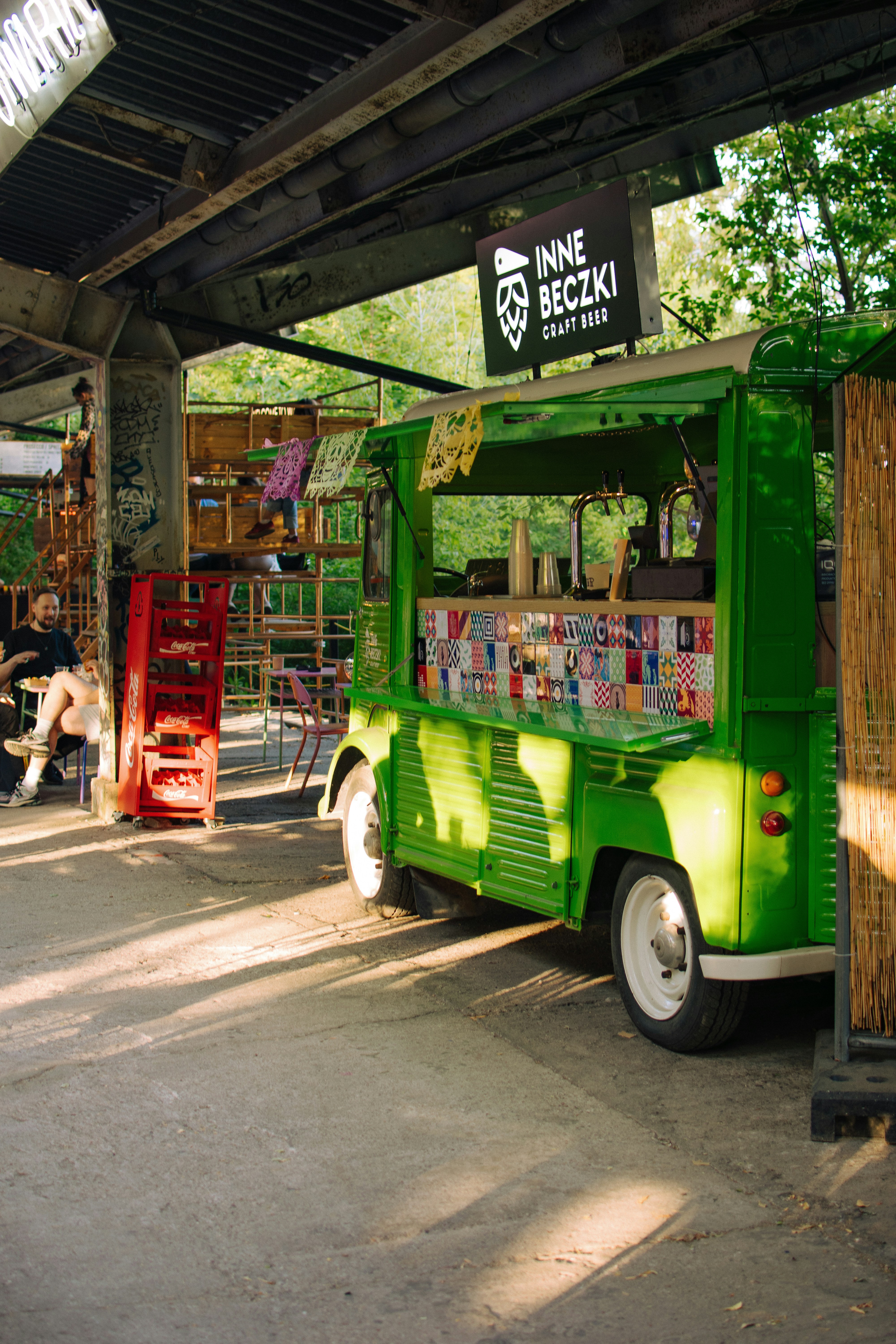 A green food truck sells craft beer.