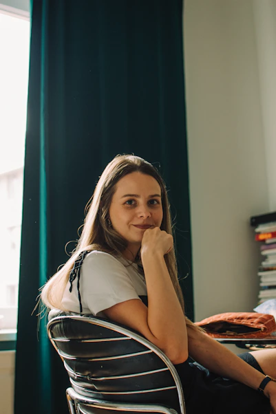 A woman smiles and rests her chin.