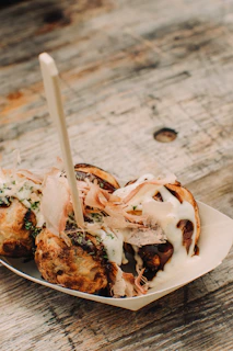 Delicious takoyaki balls on a wooden table.