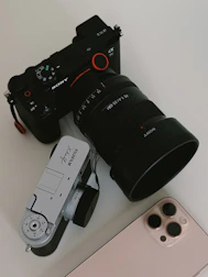 Cameras and a phone are arranged on a surface.