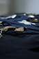 Graduation tassels rest on a dark, blue cloth.