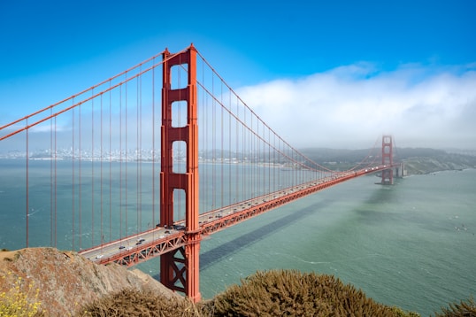 The golden gate bridge spans across the water.