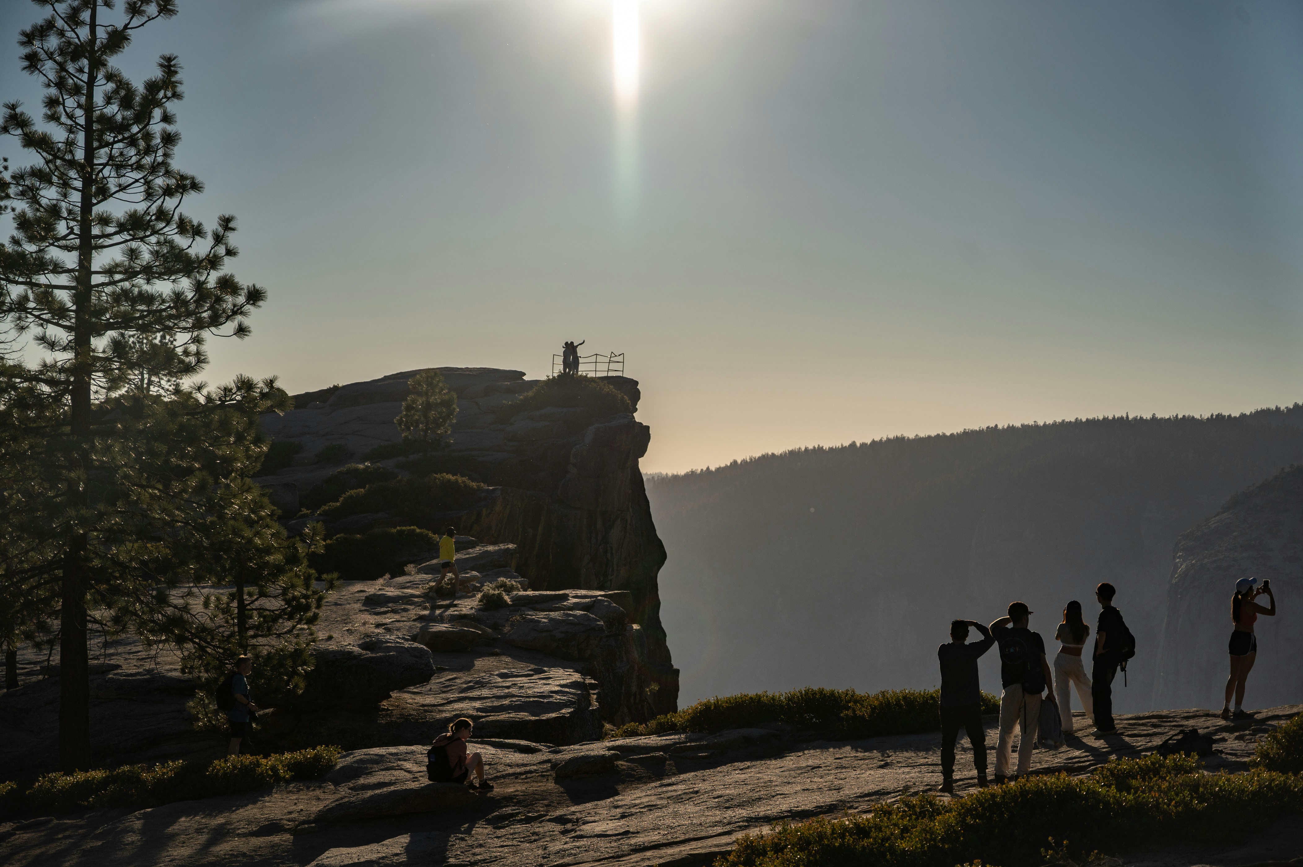 People are enjoying a scenic view from a cliff.