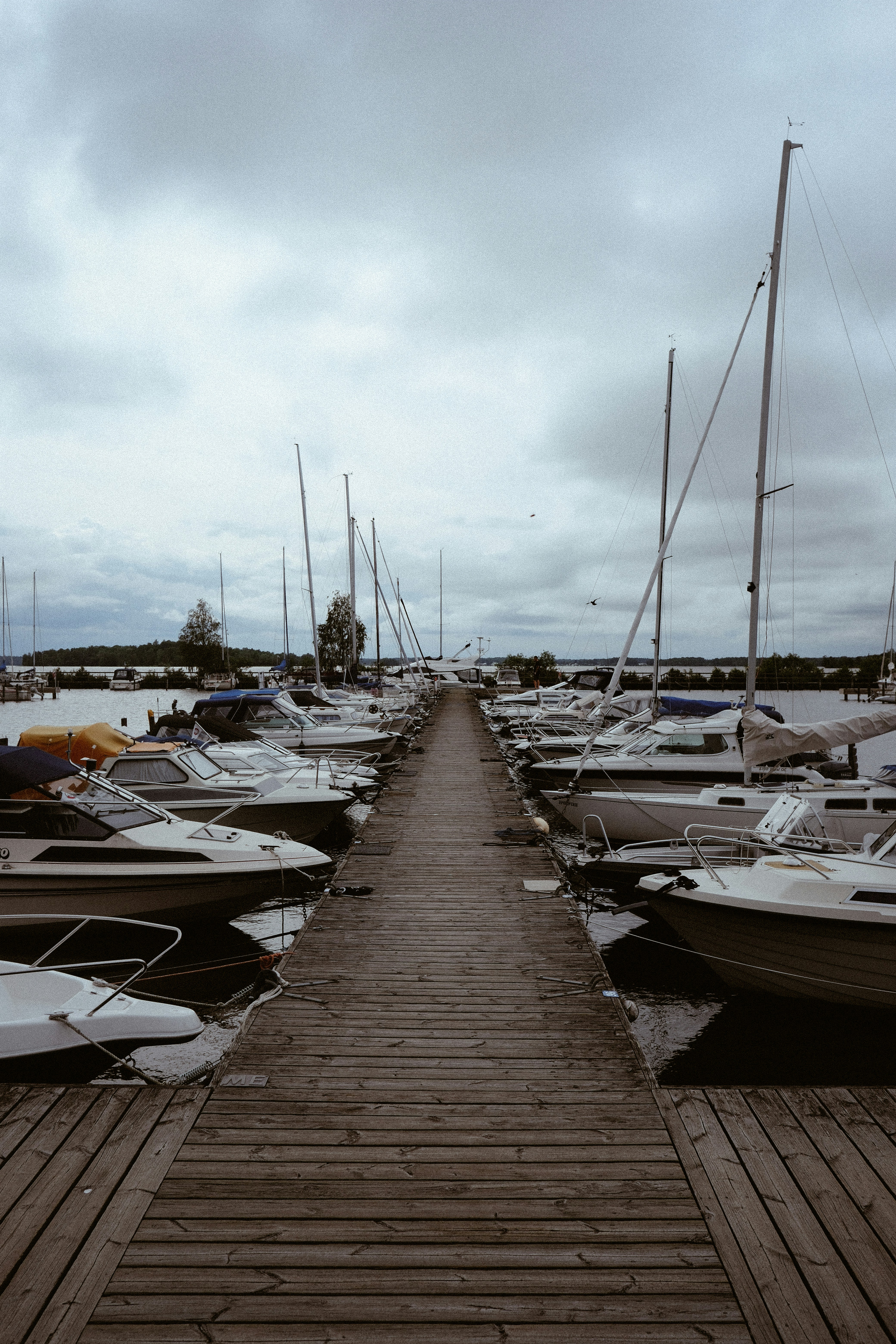 Boats are docked along a long wooden pier.