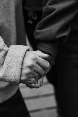 Two people holding hands in monochrome.