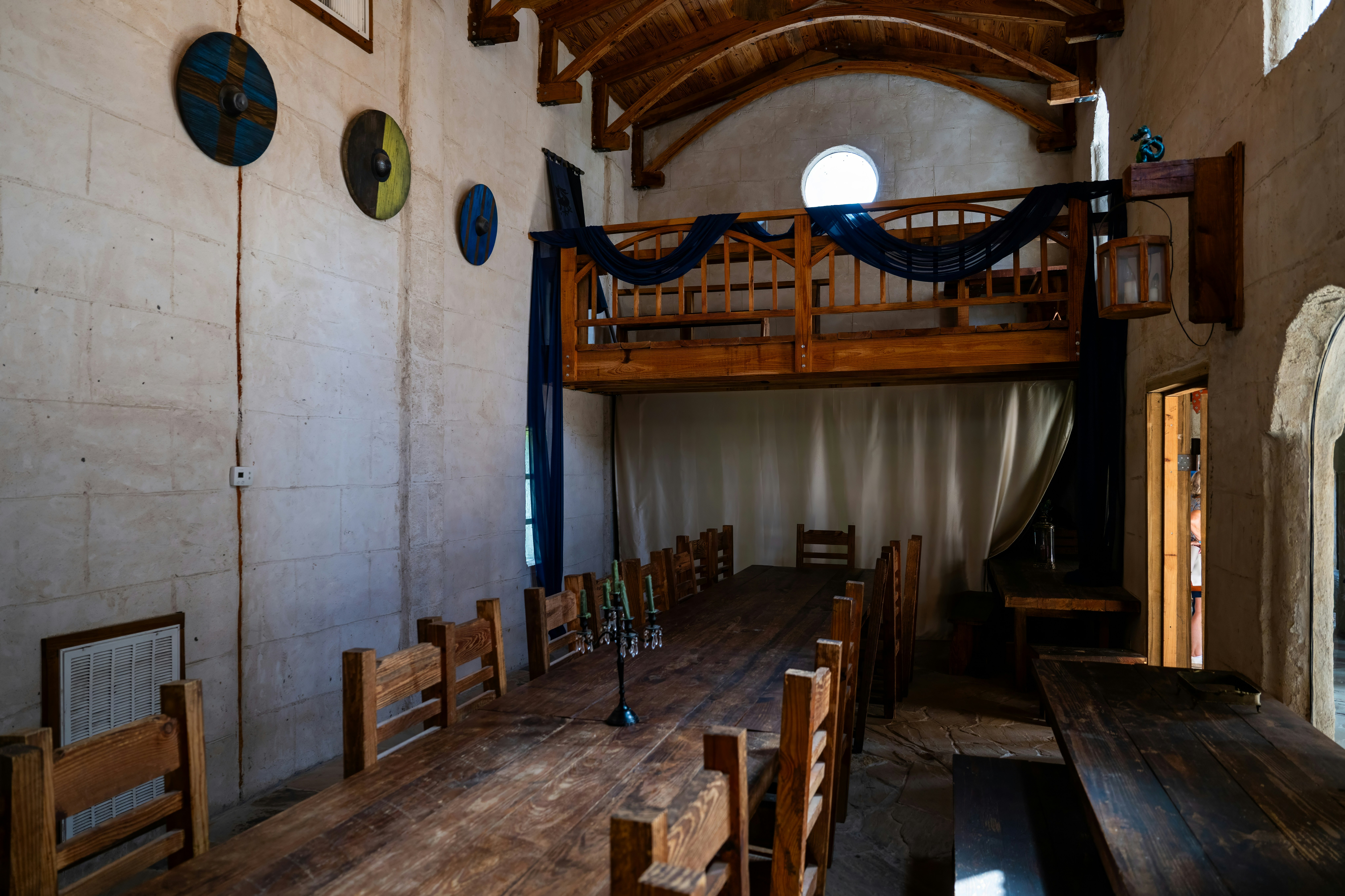 An indoor dining hall is seen with wooden furniture.
