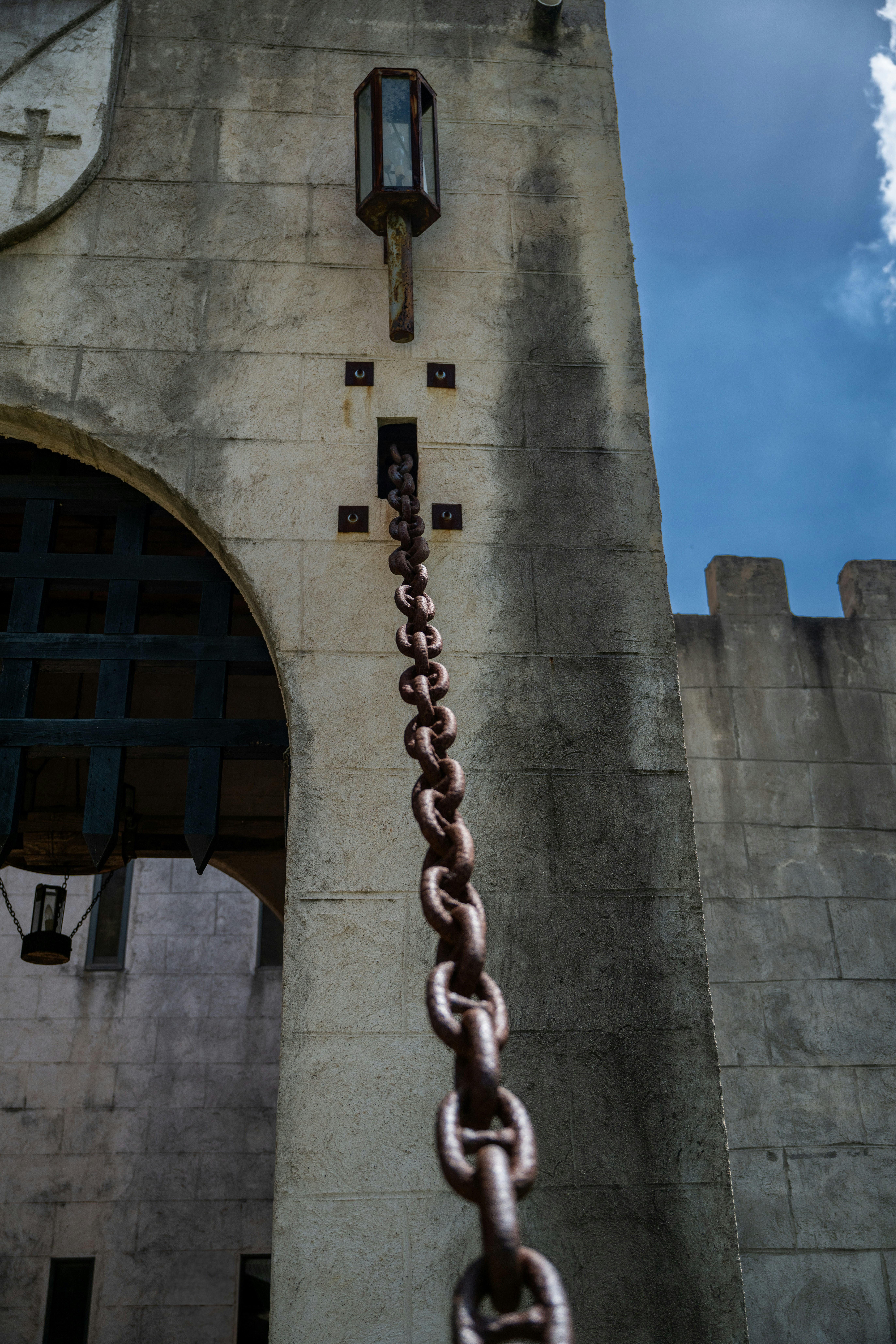 A chain hangs from a medieval castle wall.