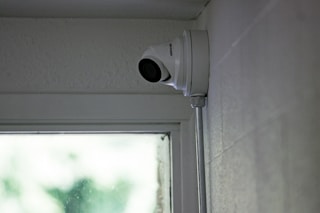 A security camera is mounted near a window.