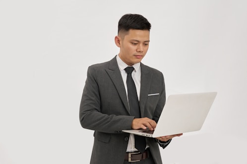 A businessman types on a laptop.