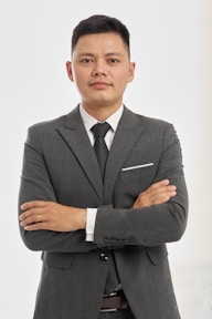 Confident businessman in a suit, arms crossed.