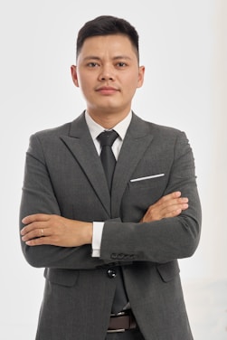 Confident businessman in a suit, arms crossed.