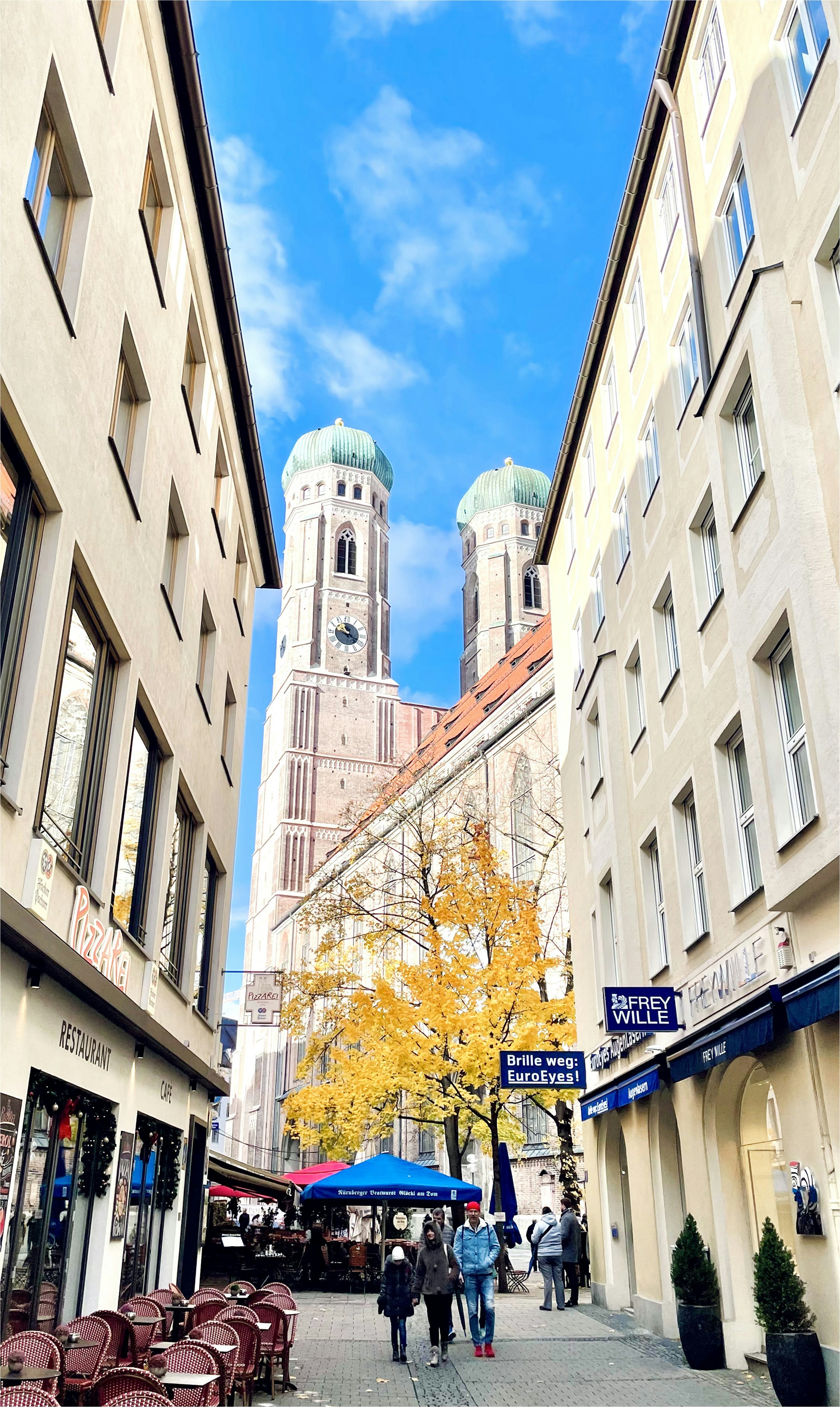 A narrow street leads to a tall church.