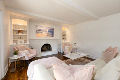 A cozy living room with white walls and fireplace.