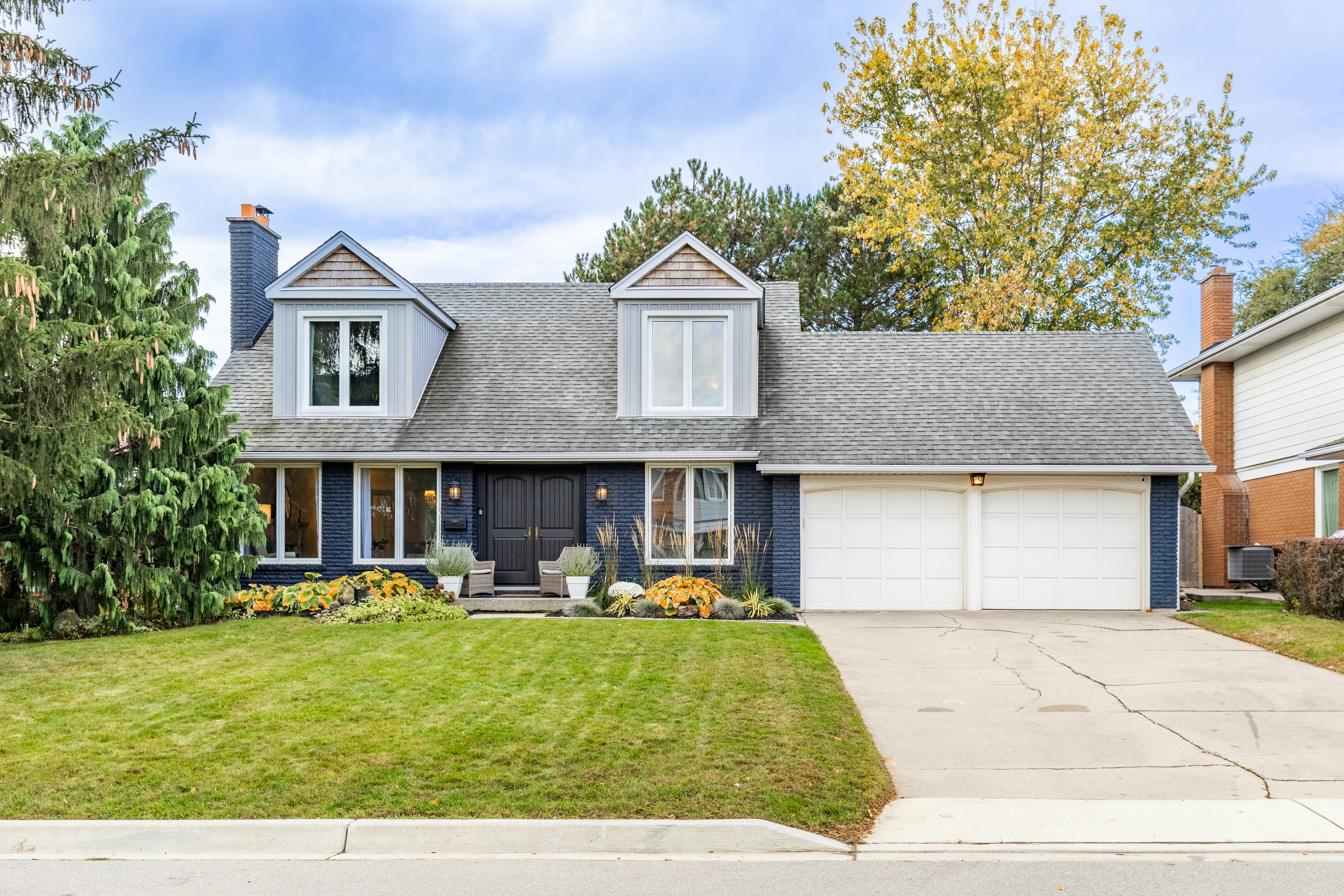Nice house with two-car garage and green lawn.