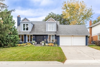 Nice house with two-car garage and green lawn.