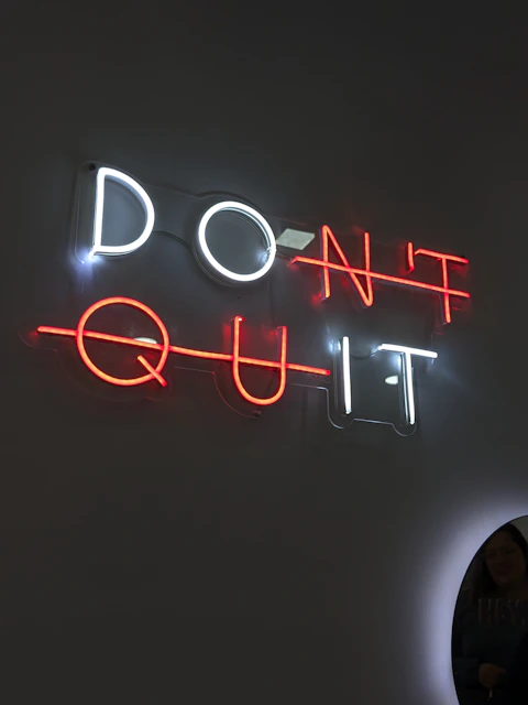 The neon sign says "don't quit."